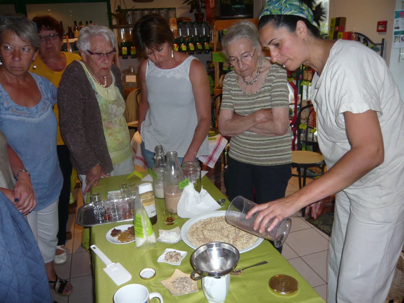 Ysabel animant un atelier de cuisine vivante devant un groupe attentif